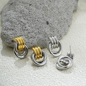 Detail of 18K gold and silver intertwined multi-layer hoop earrings on natural stone