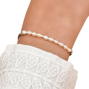 Detail of minimalist white pearl bracelet with black cord and elegant lace cuff accessory
