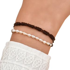 Close-up of woven brown leather cord bracelet paired with natural freshwater pearls