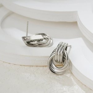 Close-up of interlocking silver triple circle stud earrings in minimalist metal design