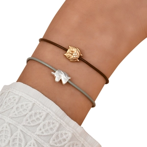 Detail of owl and unicorn pendants on minimalist leather cord bracelets with lace