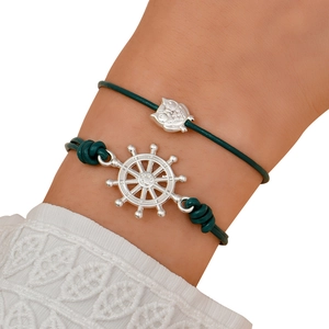 Two-piece leather rope bracelet set with owl and ship wheel pendants on model wrist