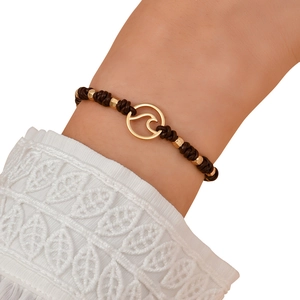 Detail of nautical leather bracelet with golden ocean wave pendant and metallic beads