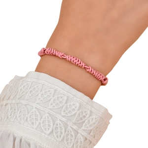 Detailed view of pink braided leather rope bracelet with textured spiral knots on wrist