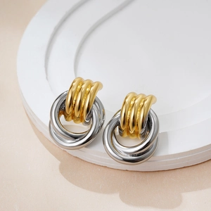 Close-up of interlinked 18K gold textured and smooth silver circles in dual-tone design