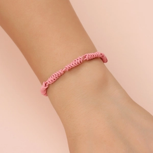 Pink braided leather rope bracelet with pearl accents shown on a female wrist