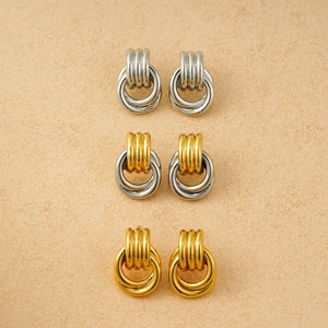 Detailed view of layered triple hoop earrings in silver, gold, and mixed two-tone metal finishes