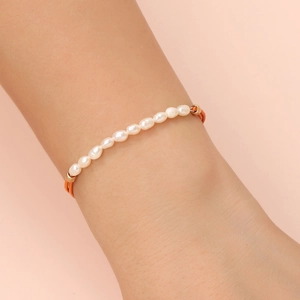 Detail of freshwater pearl bracelet with orange leather cord and gold metal accents