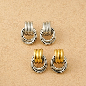 Detail of twisted double hoop earrings in silver and two-tone gold finishes
