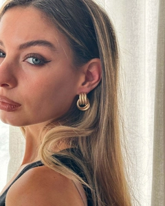 Close-up of 18K gold-plated triple-layer textured hoop earrings on a female model