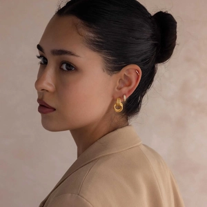 Detail view of 18K gold-plated double hoop earrings with spiral texture on professional model