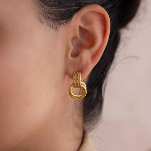 Detail of 18K gold intertwined rope-textured earrings shown on a model's ear