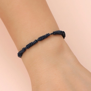 Macro shot of dark blue hand-woven leather cord bracelet with spiral knots on wrist