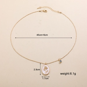 Dettaglio della collana con pendente floreale ovale dorato con dimensioni e peso