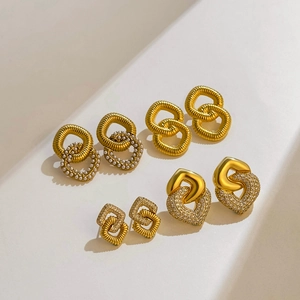 Détail d'un ensemble de boucles d'oreilles dorées 18K avec perles et zircons cœur