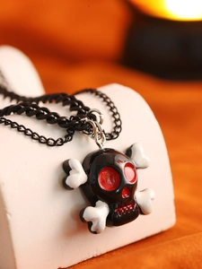 Makroansicht der Gothic-Totenkopfkette mit roten Emaille-Augen auf weißem Ständer