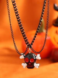 Detail einer zweilagigen Halloween-Halskette mit schwarzem Totenkopf auf orangem Hintergrund