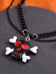 Makroaufnahme von schwarzem Gothic-Totenkopf-Anhänger mit roten Details und Kette