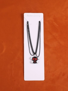 Detail einer doppellagigen schwarzen Gothic-Kette mit Totenkopf- und Knochenanhänger