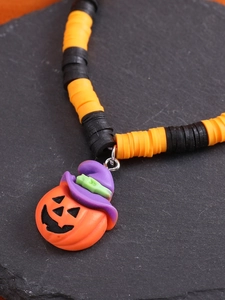 Detail der Halloween Kürbis-Halskette mit orange-schwarzen Tonperlen auf Steinuntergrund