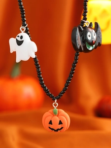 Halloween-Halskette mit Geist, Fledermaus und Kürbis-Anhängern auf orangefarbenem Stoff