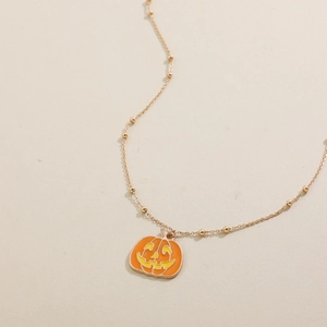 Detail der Kürbis-Halskette an einer goldenen Perlenkette für Halloween-Partys