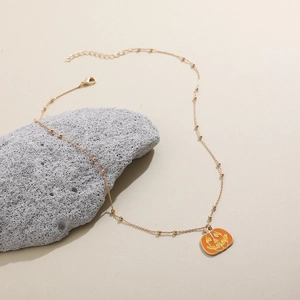 Detailansicht der goldenen Perlenkette mit orangefarbenem Emaille-Kürbis und Karabinerverschluss