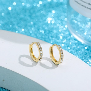 Aros dorados minimalistas con pavé de circonitas en una lujosa vista macro de 45 grados