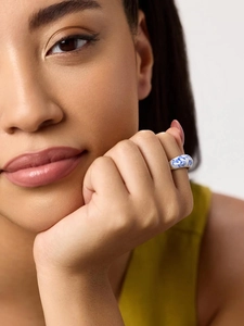 Gros plan d'une bague en céramique style porcelaine bleue et blanche avec anneau en or