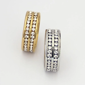 Detalle macro de anillos con doble fila de cristales en acabados oro y plata pulida
