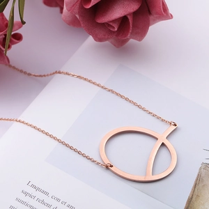 Minimalist rose gold stainless steel geometric ring necklace displayed on a white card