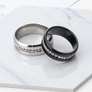 Black and silver stainless steel rings with center cz stones on marble stand