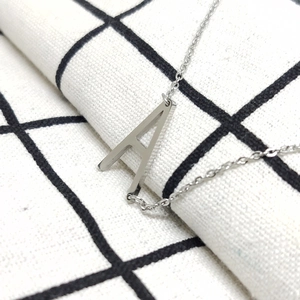 Detail van de zilveren ketting met de letter A hanger van roestvrij staal
