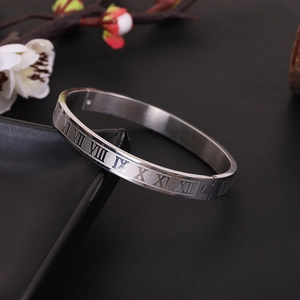 Modern stainless steel bangle featuring engraved Roman numerals on a black background