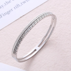 Polished stainless steel oval bangle with Greek fret pattern and crystal inlay detail