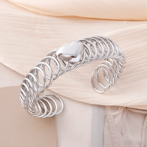 Polished silver heart charm on a flexible stainless steel spiral wire cuff bracelet