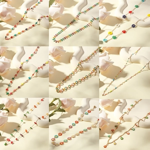 Collection of colorful enamel daisy and heart charms on gold-plated stainless steel chains