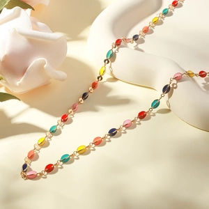 Close-up of bohemian colorful enamel bead necklace with gold-plated metal chain details
