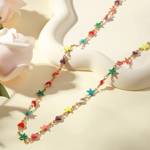 Detail of gold chain necklace featuring colorful enamel star and heart shaped charms