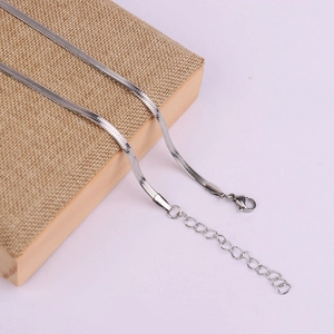 Close-up of silver flat snake chain necklace with lobster clasp and adjustable tail