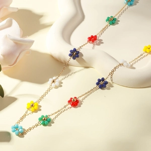 Detail of colorful beaded daisy flowers on a gold-plated stainless steel chain