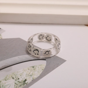 Vista de detalle del anillo de resina transparente con motivos de caras sonrientes