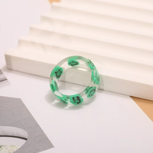 Primer plano detallado de un anillo de resina transparente con un diseño de cara sonriente