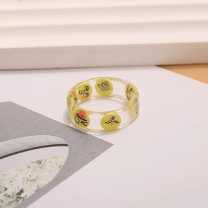 Primer plano de caras sonrientes de dibujos animados en un anillo de resina clara