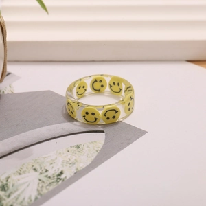 Anillo de resina transparente con patrones de smiley amarillos y acabado pulido