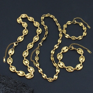 Goldenes Edelstahl Kaffee-Bohnen Gliederketten Set mit Armband auf dunklem Stein