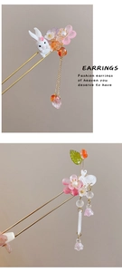 Detail view of a Chinese wooden hair stick featuring a cute white rabbit and floral tassels