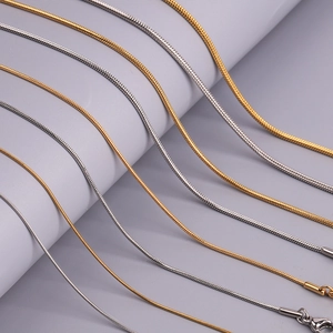 Makroaufnahme von Schlangenketten aus Edelstahl in Gold und Silber mit Karabiner