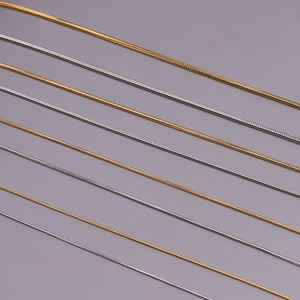 Detailansicht der schlanken Schlangenketten in Gold und Silber mit feiner Metallstruktur