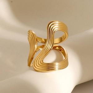Gros plan de la texture ondulée abstraite et des rainures dorées sur la bague en acier